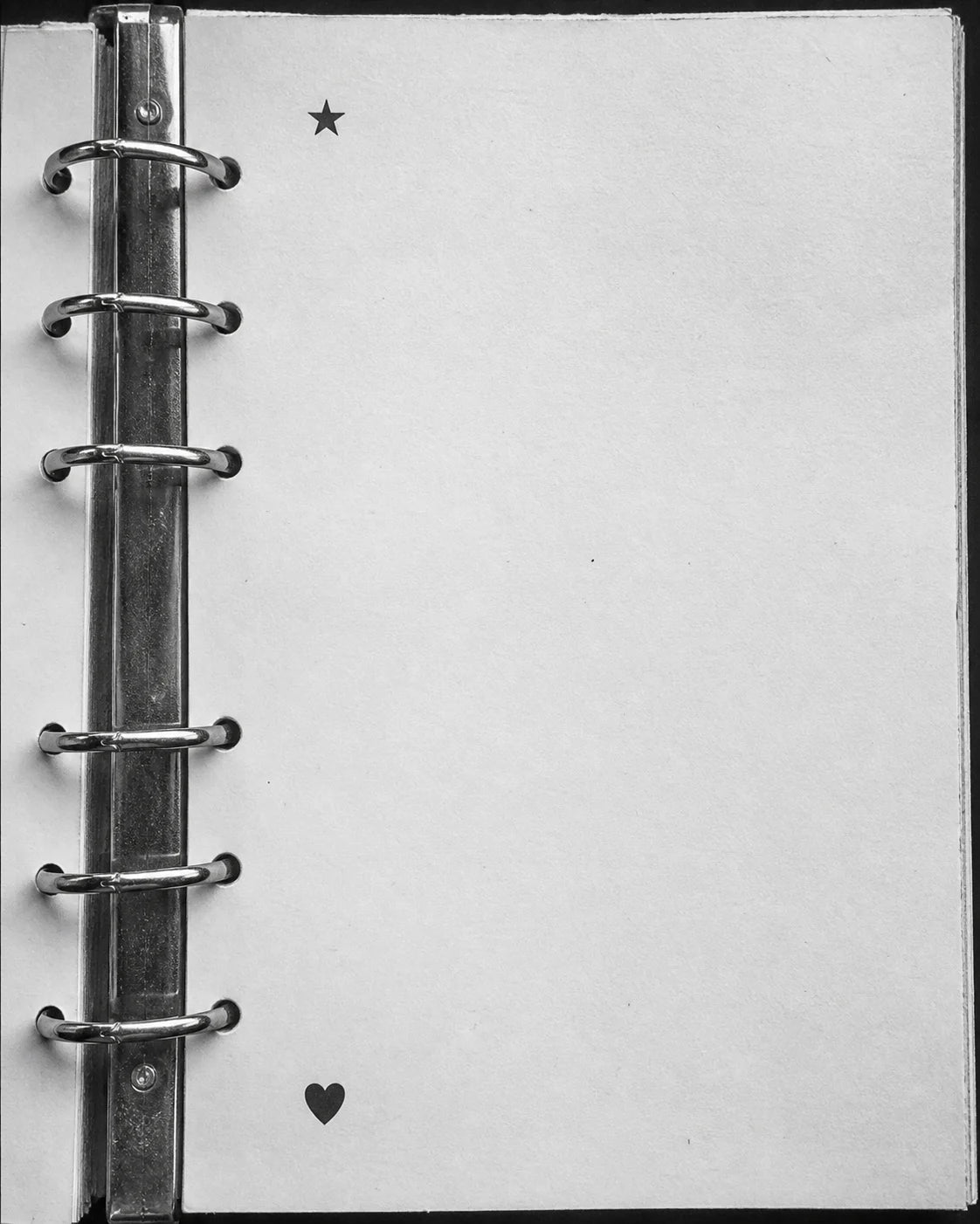 Open ring binder with a star and heart printed on a blank page